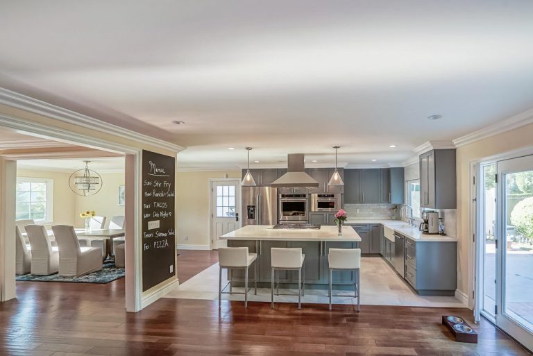 Gray kitchen with a central island and three bar stools.