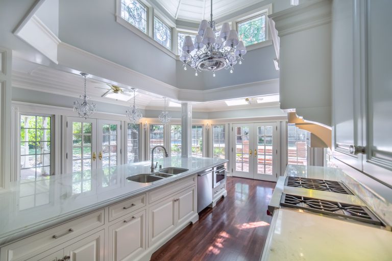 View down the kitchen beside a long island and bay windows.