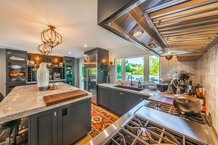 Kitchen range and hood beside the island and patterned runner.
