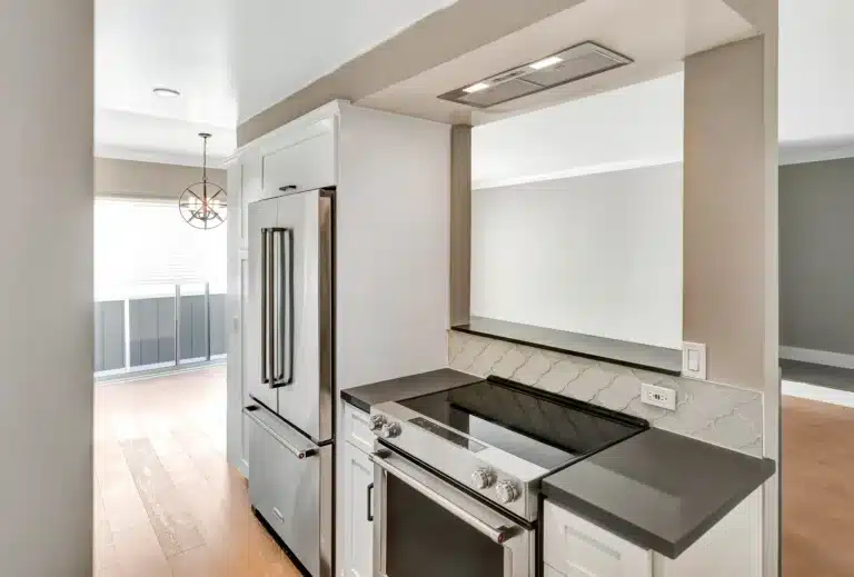 Kitchen range beneath an integrated hood with dark counters.