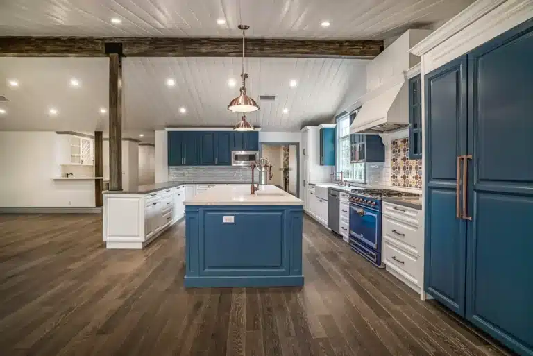 Blue-and-white kitchen with a central island and tall pantry cabinets.