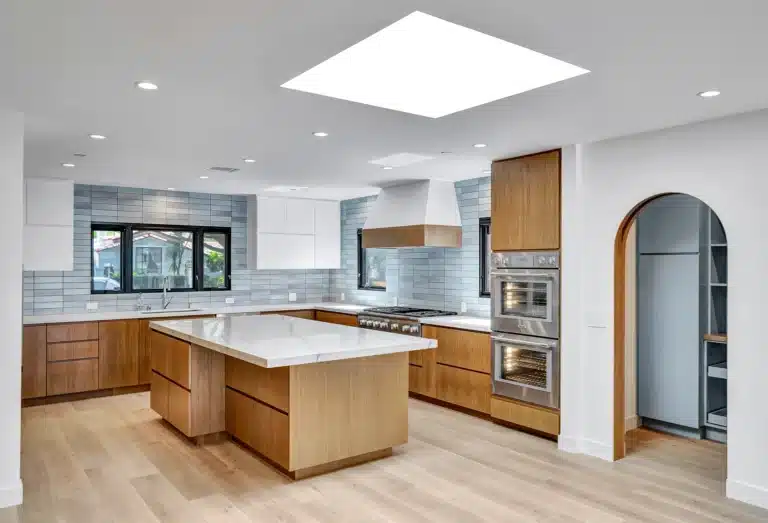 Kitchen with wood island, blue backsplash and a large skylight.