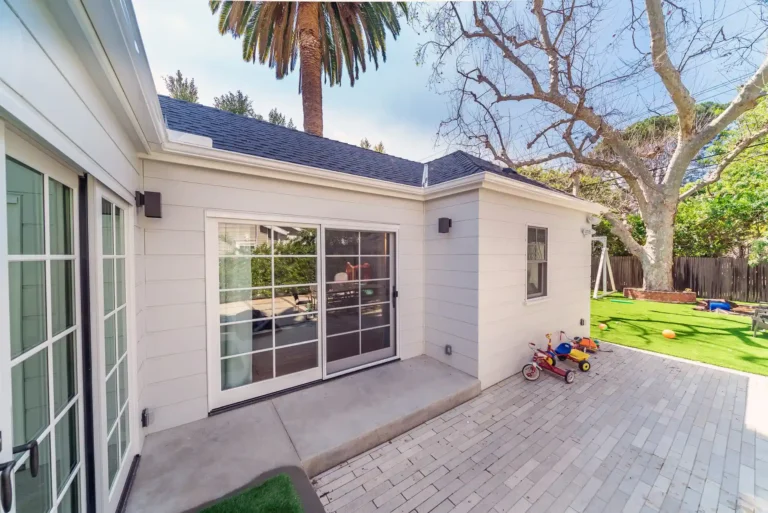 Rear exterior of the addition opening onto a paved patio.